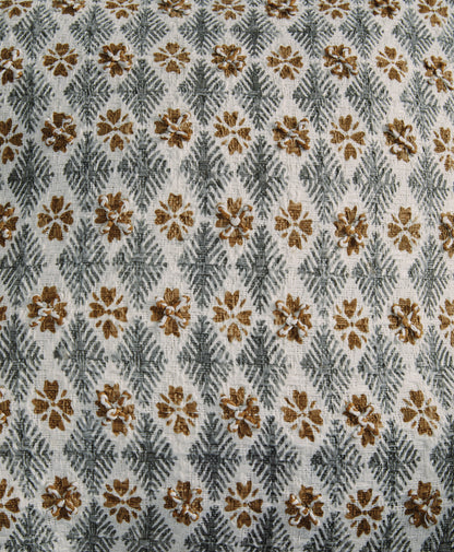 Close-up of light gray fabric with brown and gold floral and geometric pattern