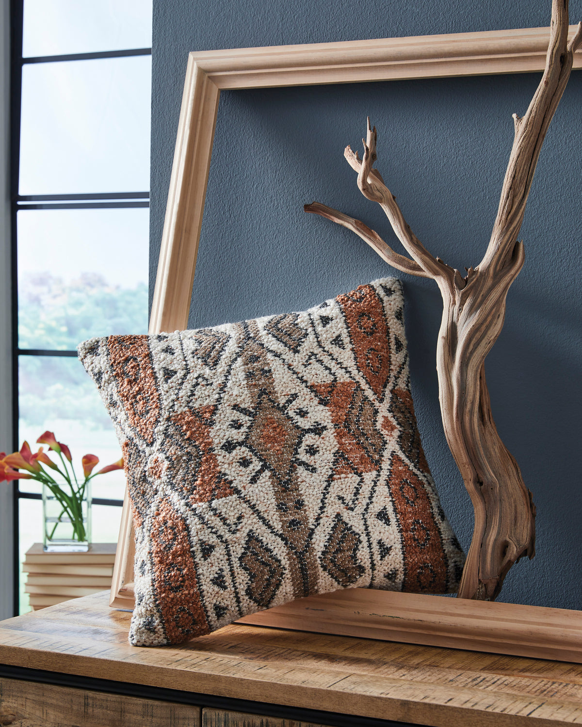 Geometric woven square pillow with brown, orange, and cream pattern