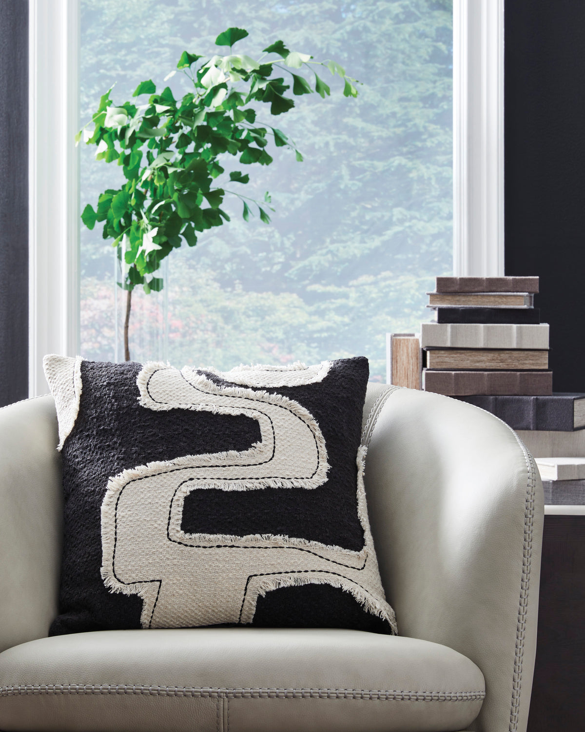 Black and cream decorative throw pillow with outlined abstract letter E design