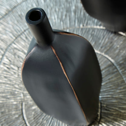 Black ceramic vase neck and shoulder detail with copper-toned vertical seam.