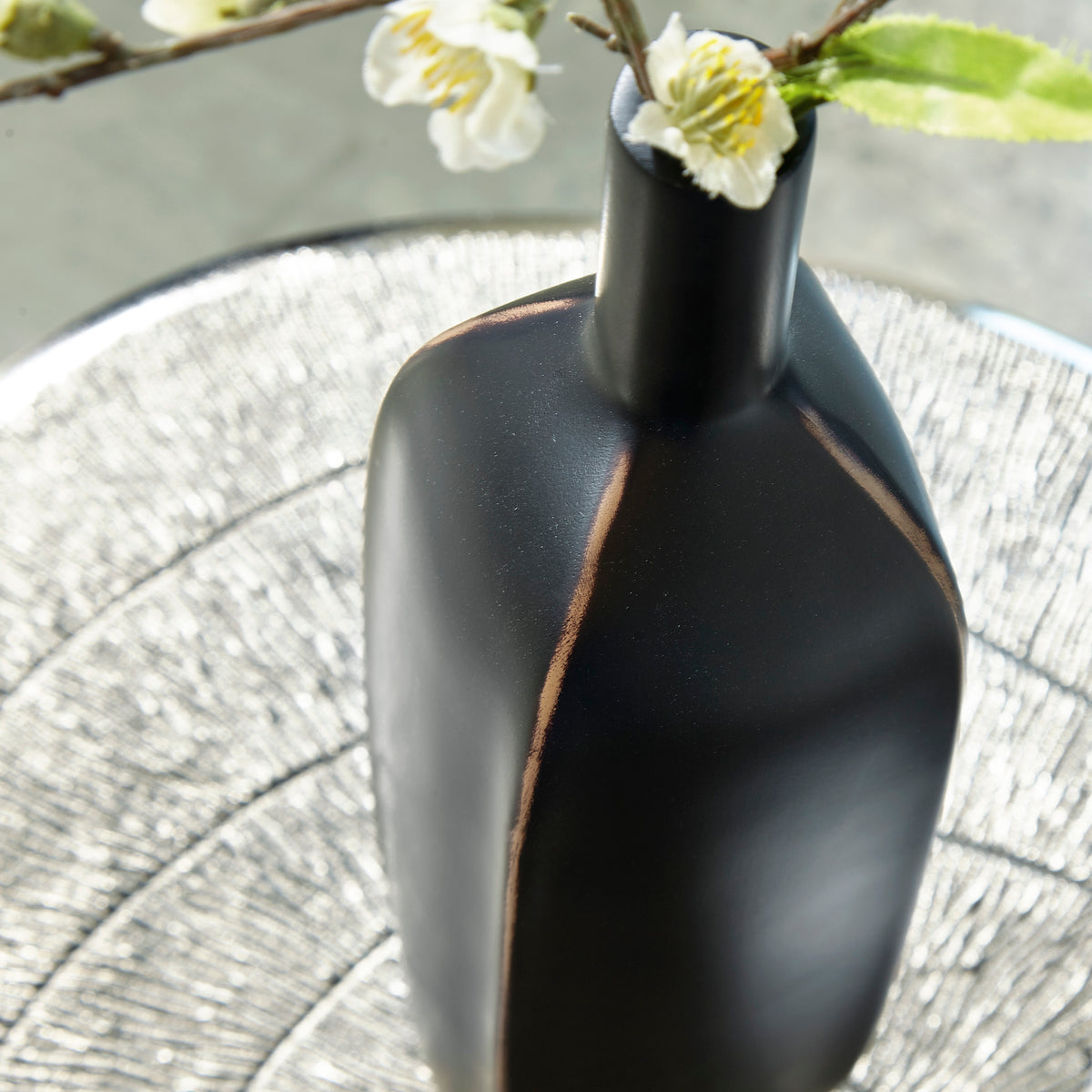 Matte black vase body with vertical copper seam line
