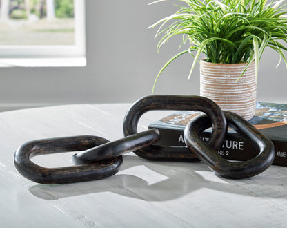 Metal sculpture with dark oval chain links, coiled and interlocked