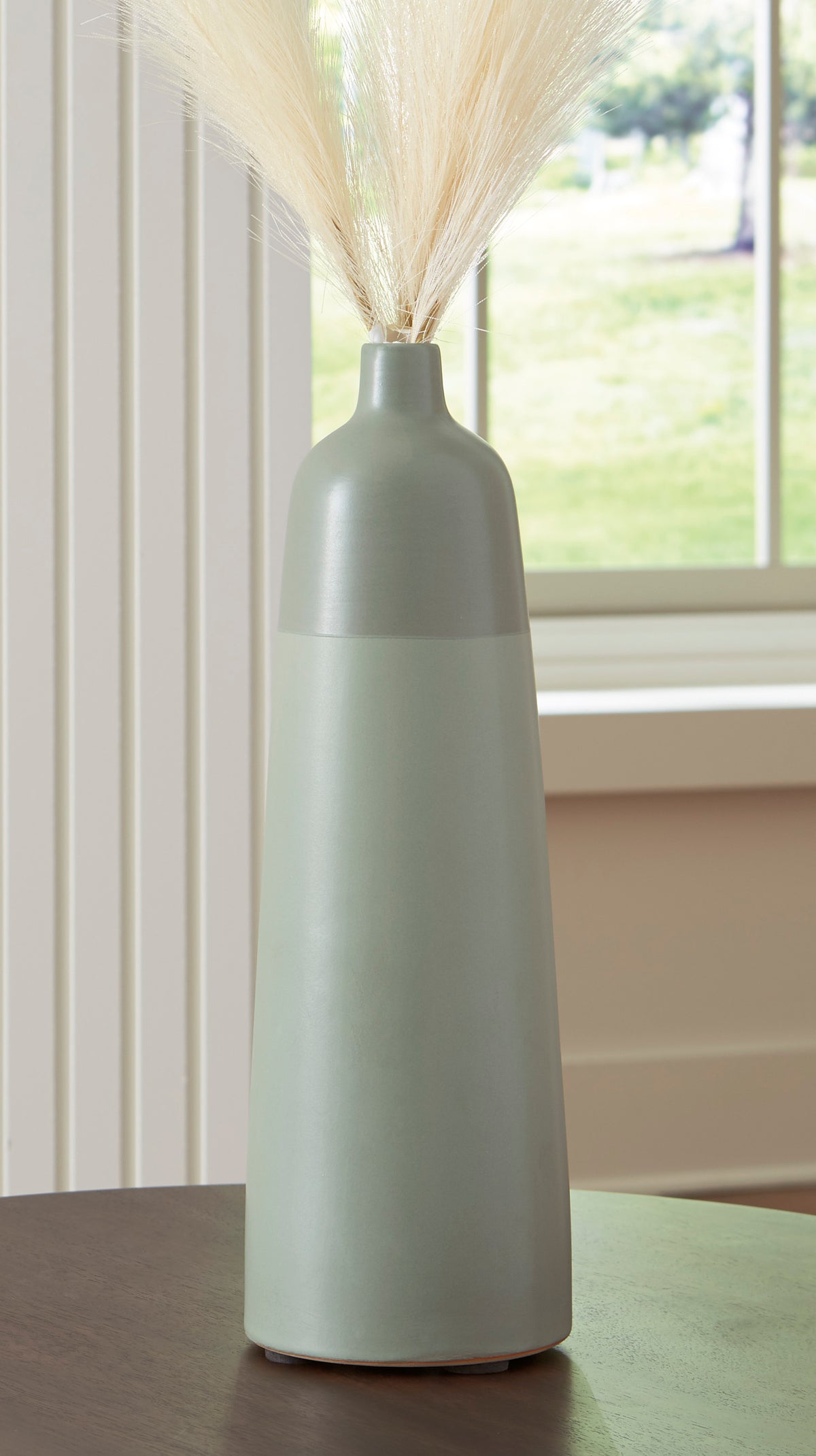 Tall matte ceramic vase with narrow neck and flared rim, with dried grass stems