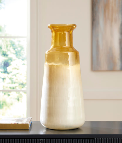 Ceramic vase standing on a shelf, amber glossy neck above a cream-to-gray body.