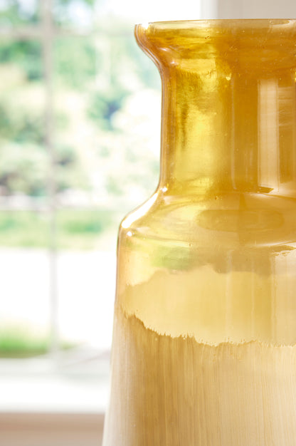 Close-up of ceramic vase neck with glossy amber glaze and cream-to-gray ombre finish.