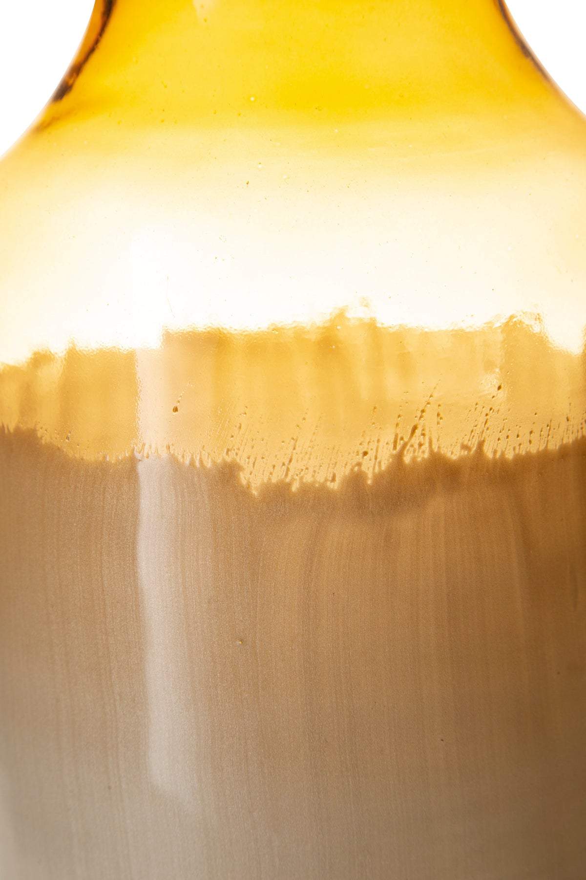 Ceramic vase close-up showing amber glaze drip and cream-to-gray gradient body.
