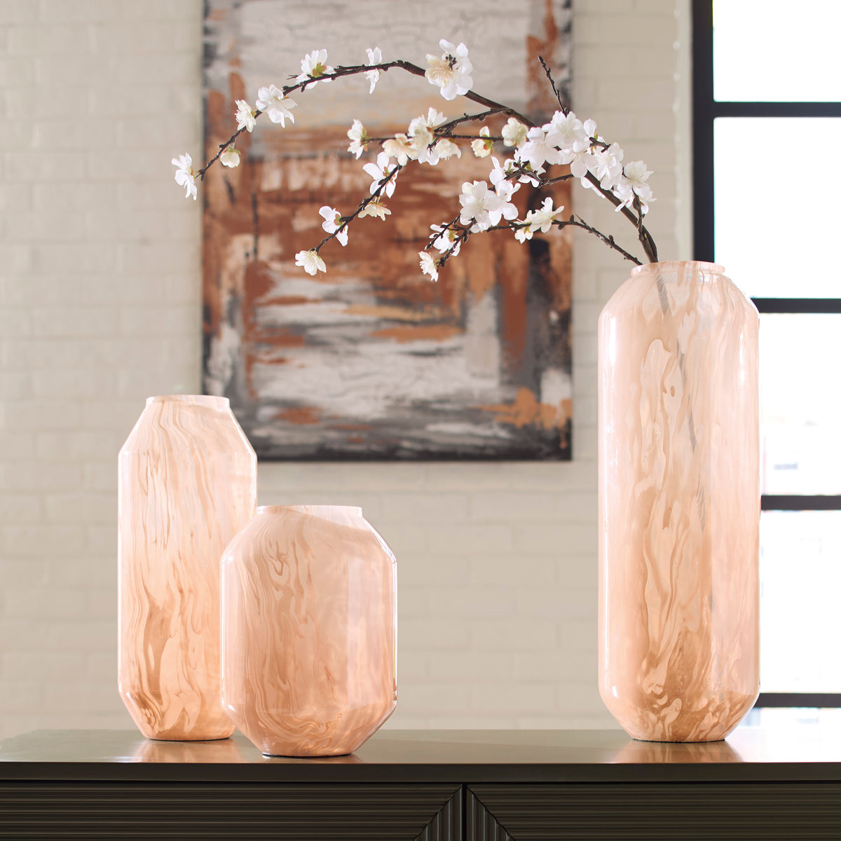 Peach glass vases with wavy finish and white blossoms arrangement