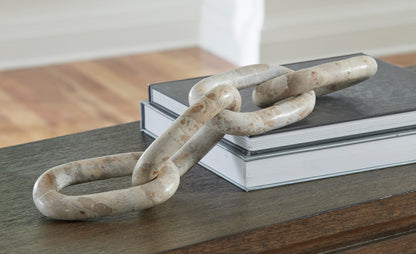Interlocking chain-link sculpture with speckled light stone finish, on display