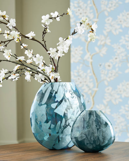 Teal glass vase with marbled finish and fluted rim holding white blossoms