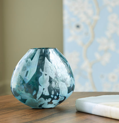Teal marbled glass vase on table with fluted top rim
