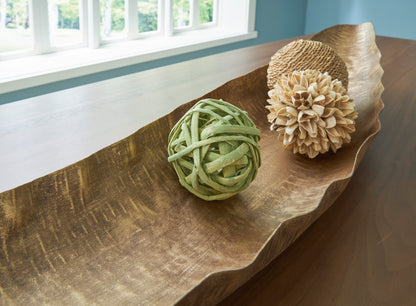 Golden-brown curved wood serving tray with green and tan pom-pom decor