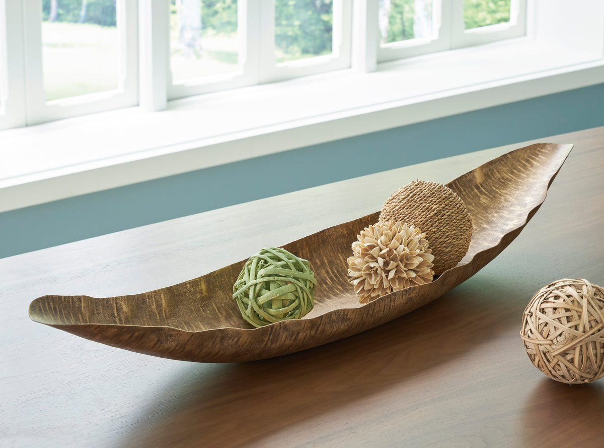 Golden-brown curved wood serving tray holding green and tan decor balls