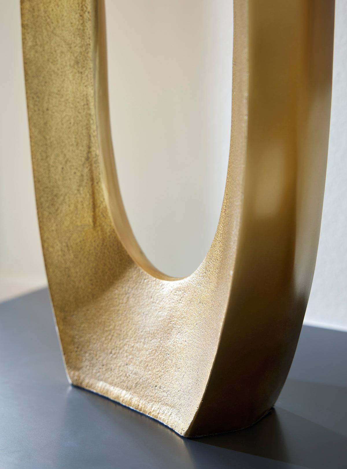 Gold-toned vase base with oval cutout opening, textured finish