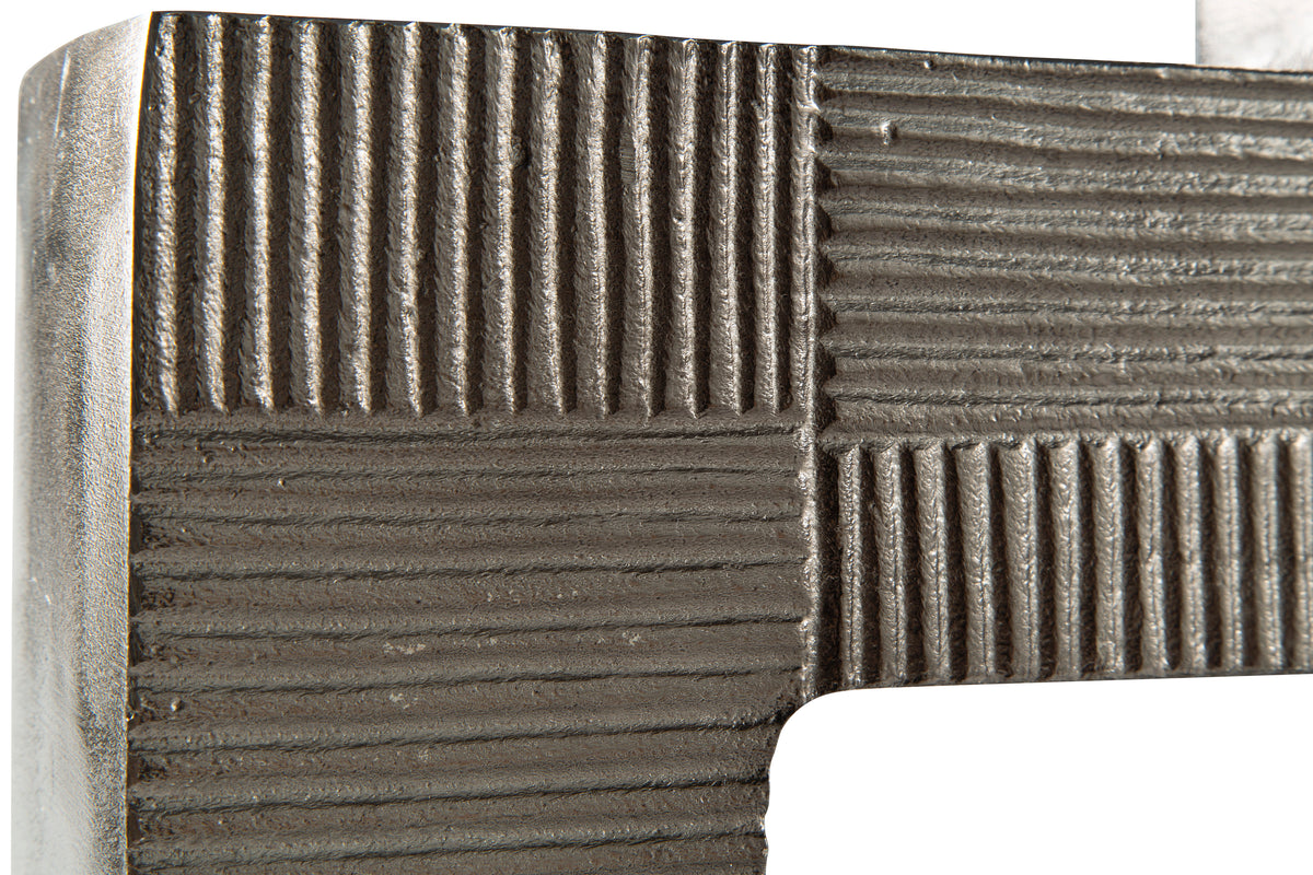 Close-up of textured metal vase top edge with striped block detailing, dark gray