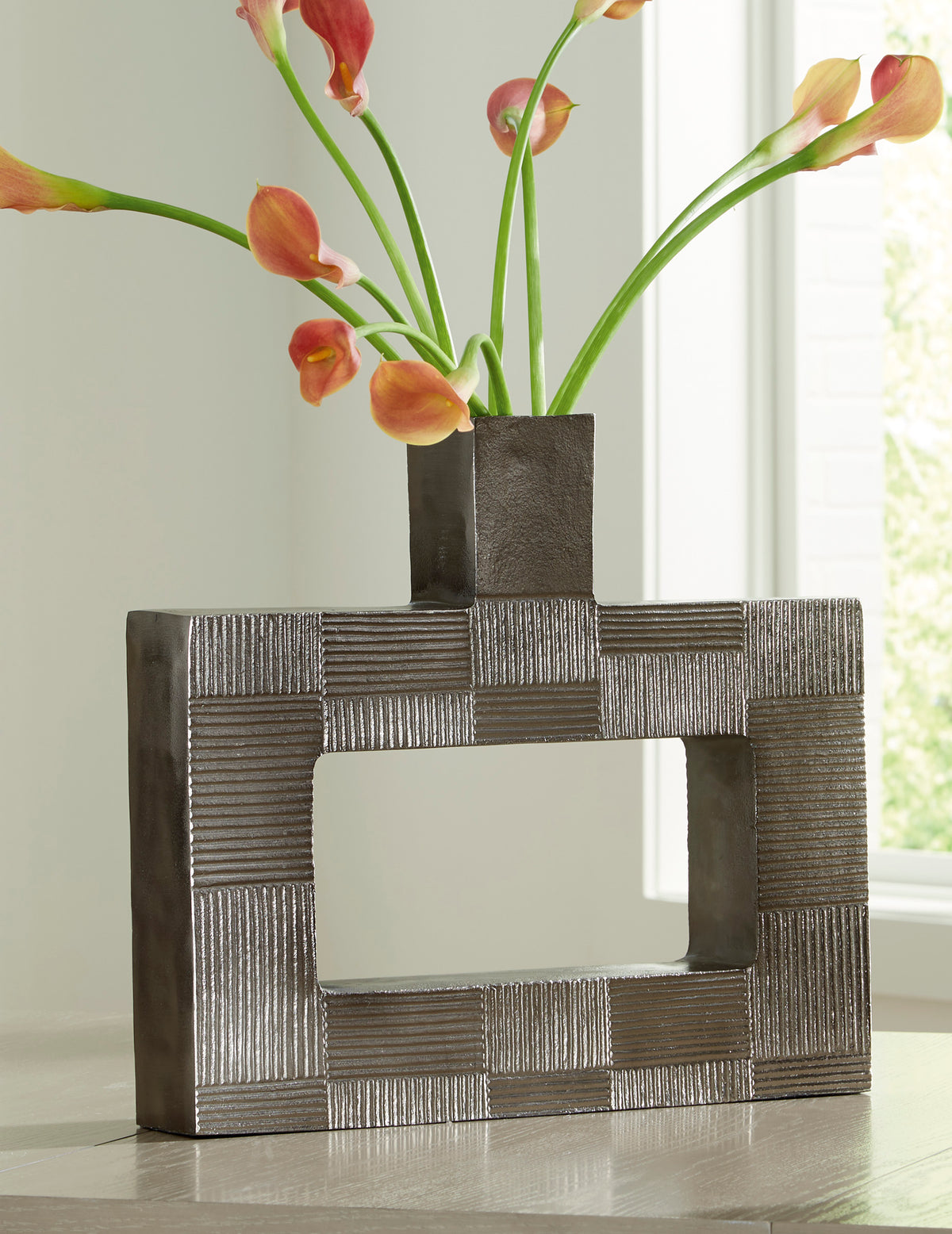 Decorative metal vase with geometric block pattern and open square cutout, dark gray