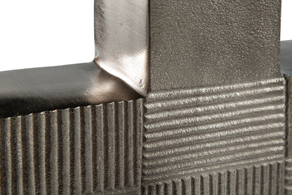 Close-up of metal vase stem and textured striped block pattern near the opening