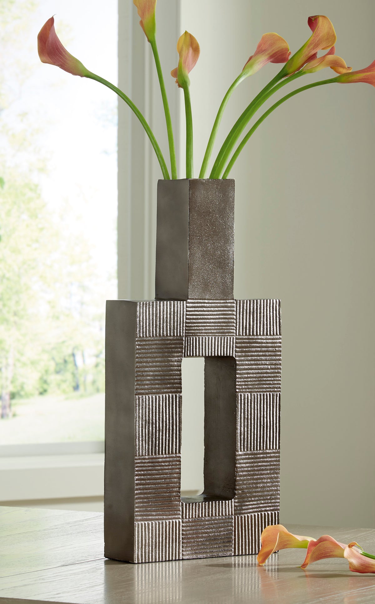 Decorative metal vase with tall cylindrical top and patchwork stripe pattern, dark gray