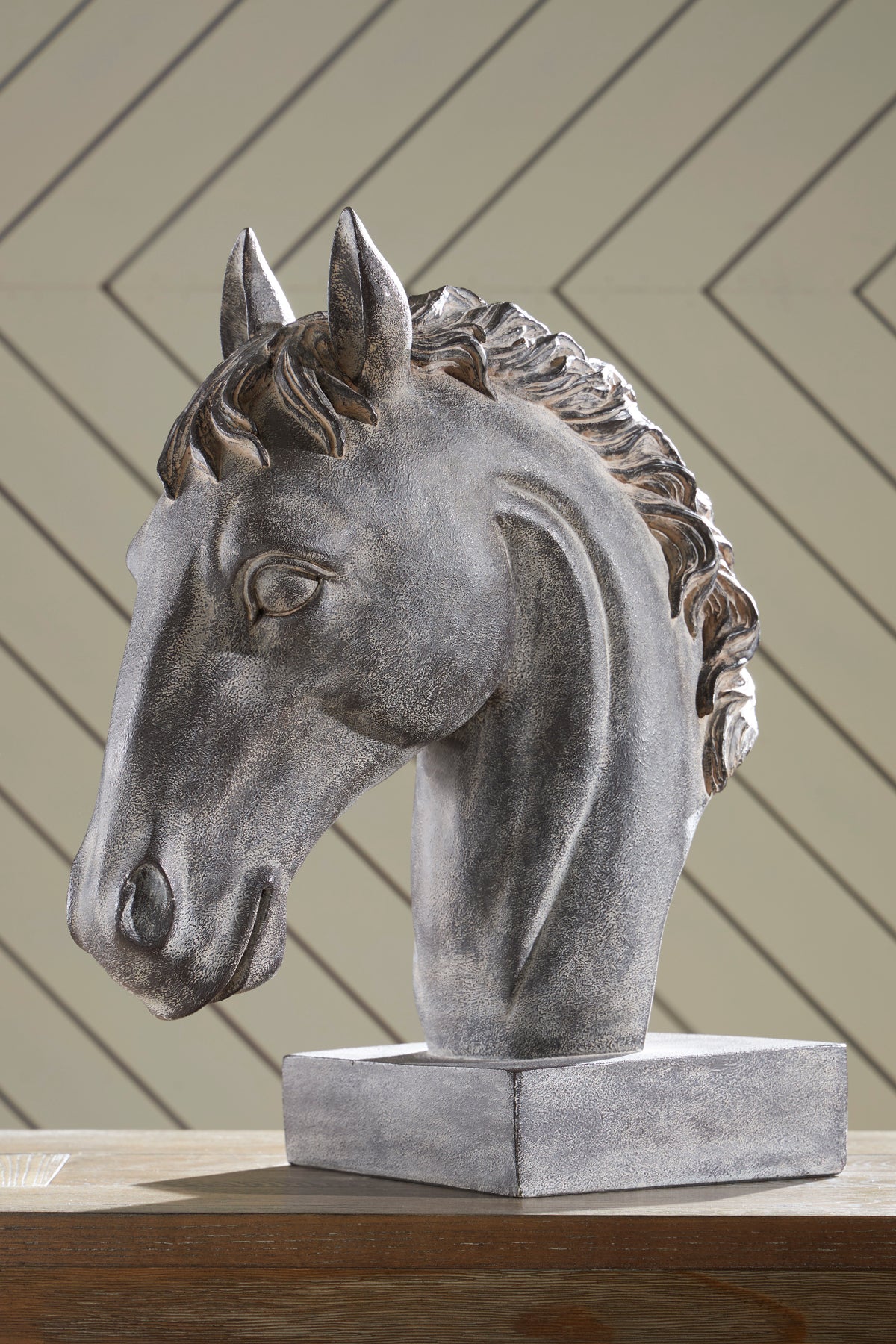 Grey horse head sculpture with flowing mane and pointed ears on square pedestal base