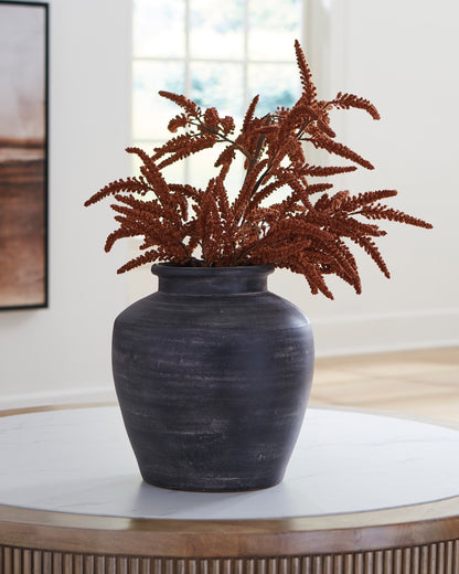 Ashley Meadie dark ceramic vase with open top and rust stems in it
