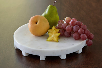 Round white ceramic serving tray with small scalloped feet