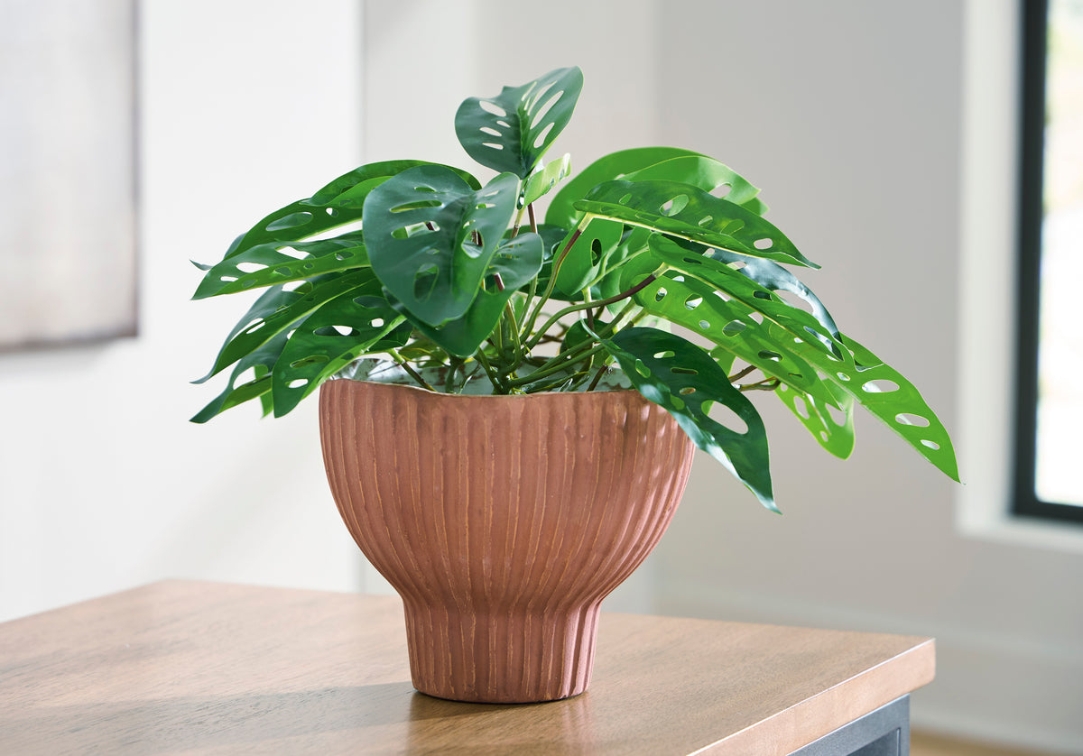 Ashley Orban ribbed vase holding green leafy stems