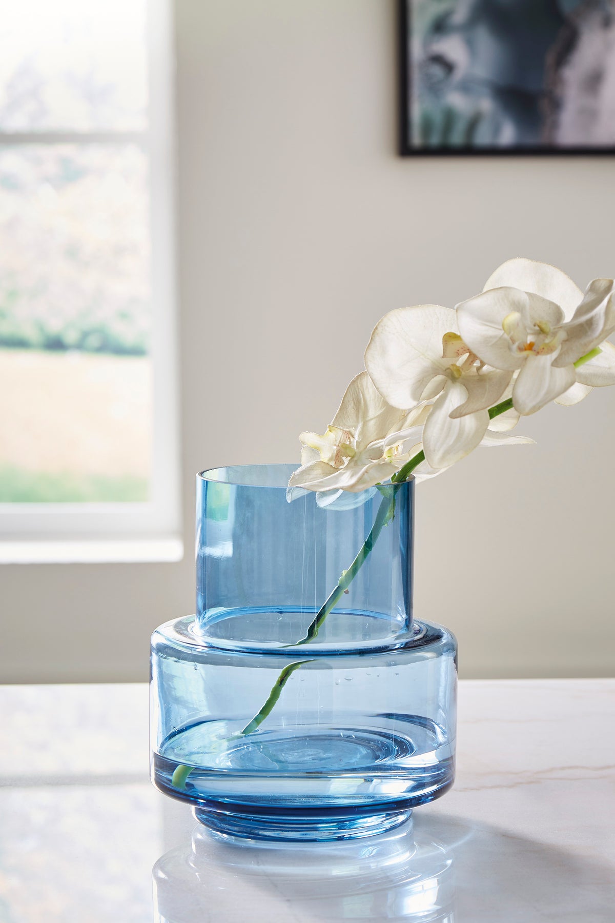 Blue glass indoor/outdoor vase with white orchid flowers