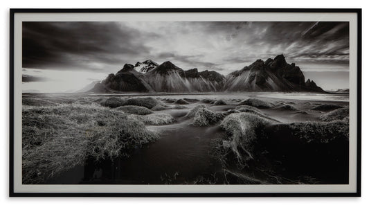 Framed black-and-white wall art with coastline path, dunes, and jagged peaks