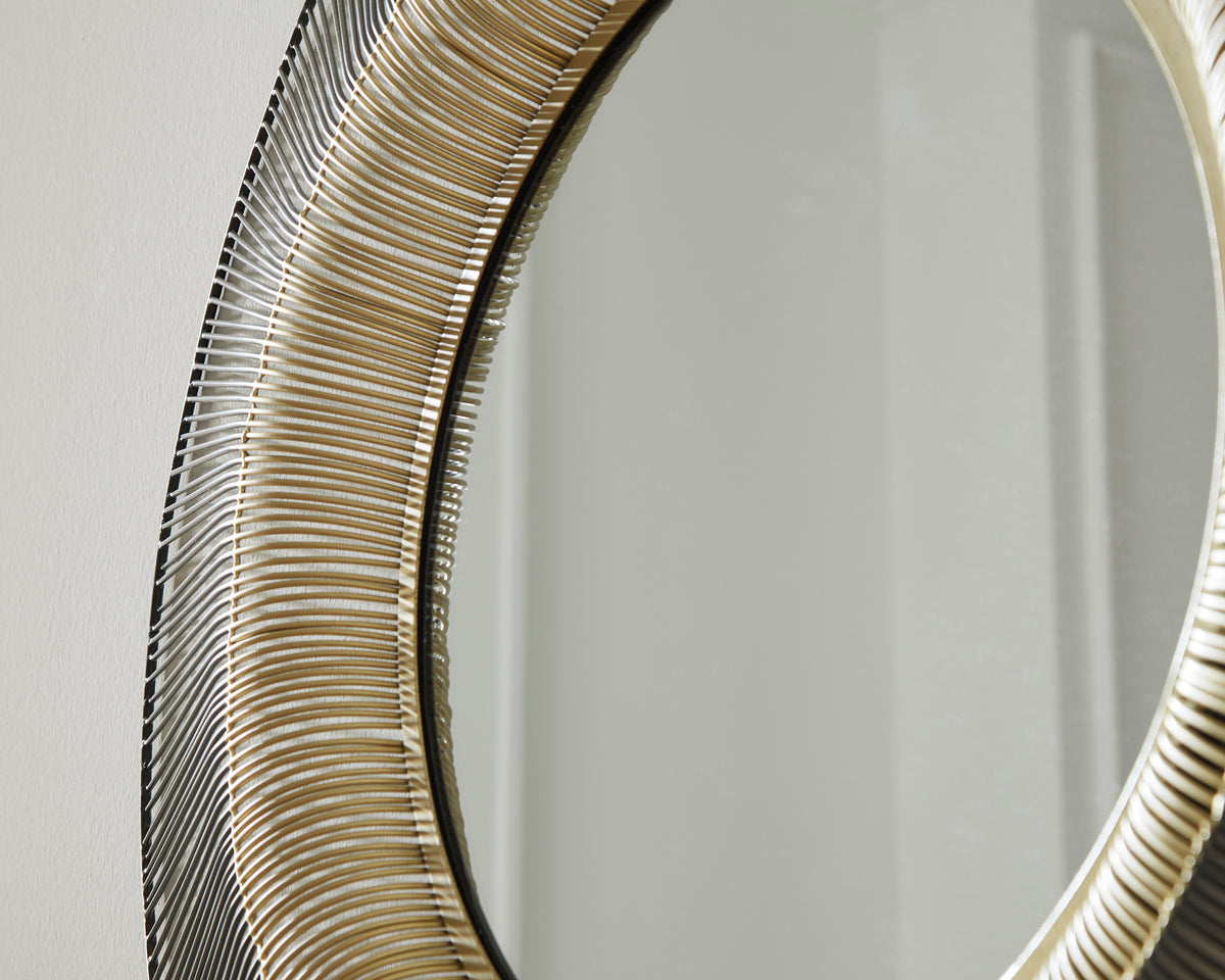 Close-up of round mirror frame edge with gold trim and black-silver linear detailing