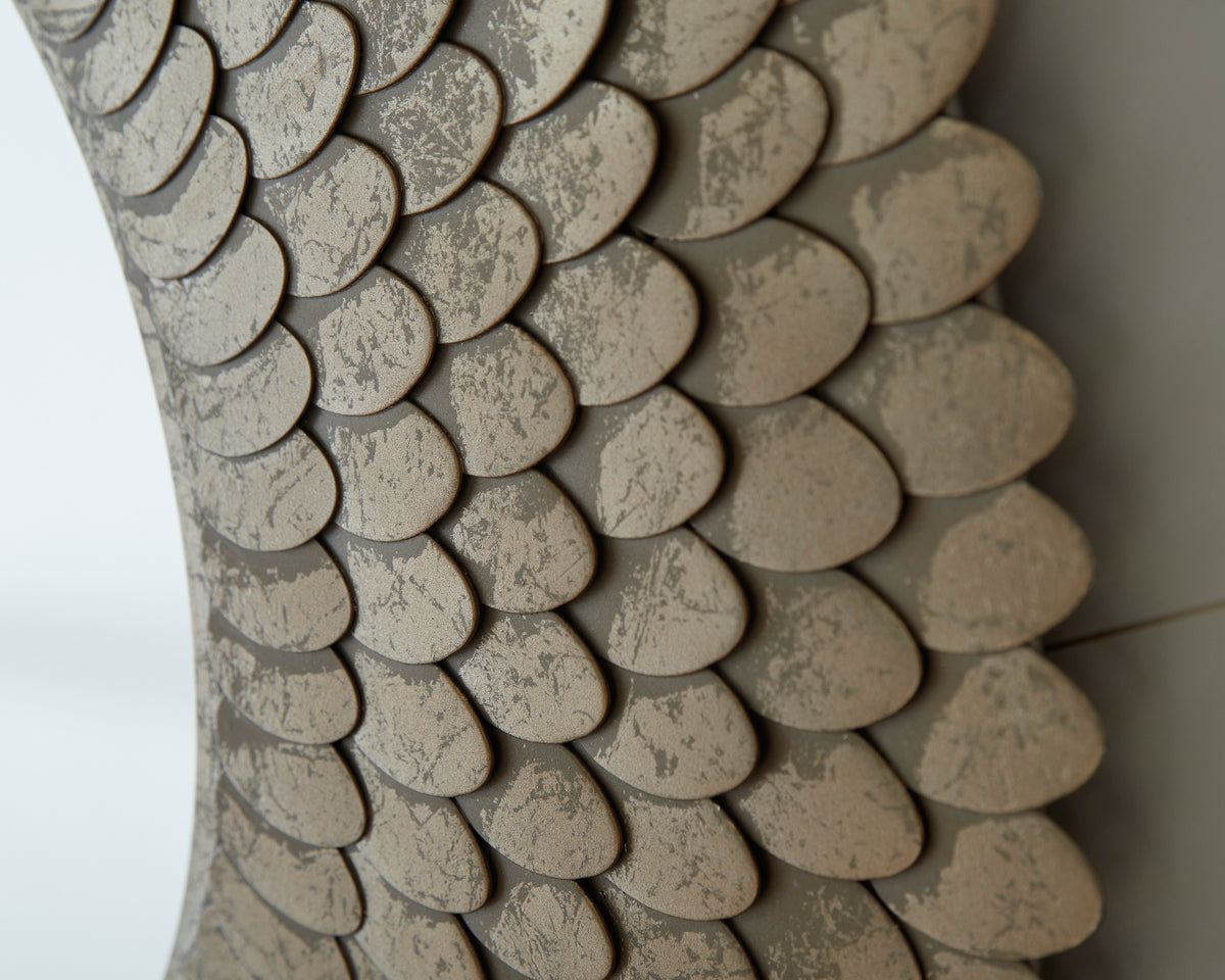 Close-up of shell-textured beige mirror frame with overlapping scales