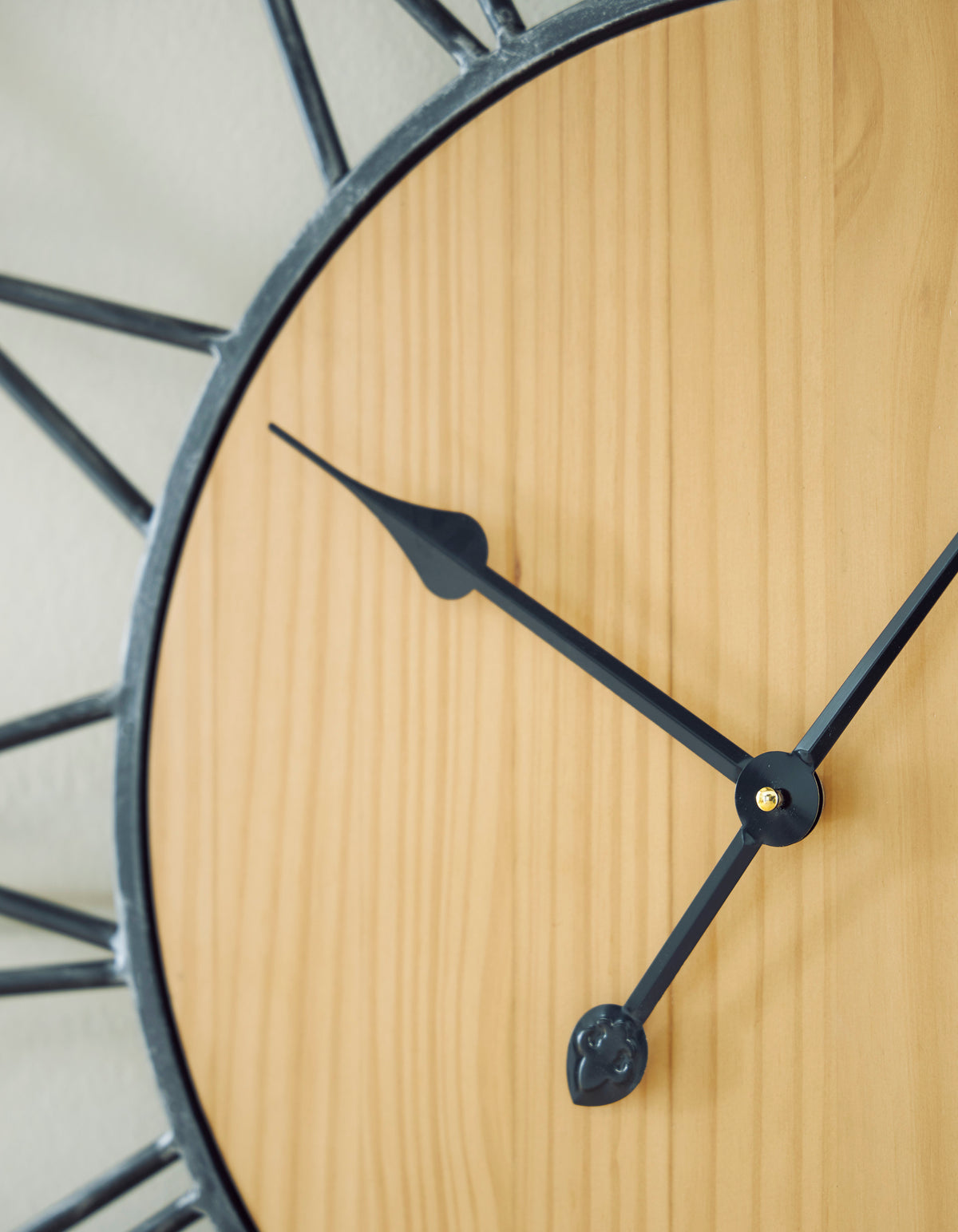 Wall clock face close-up with wood panel and black hour and minute hands