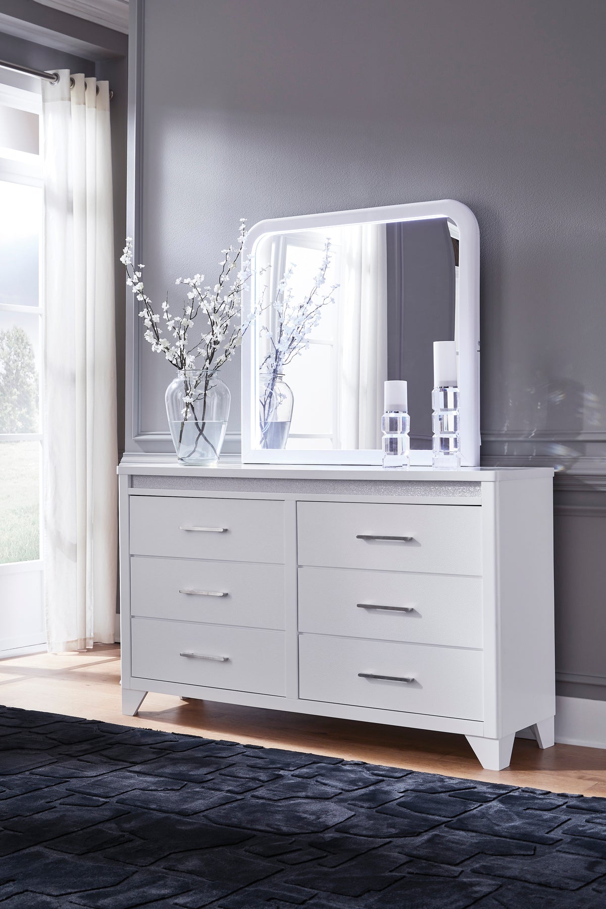 White dresser with arched mirror and multiple drawer fronts