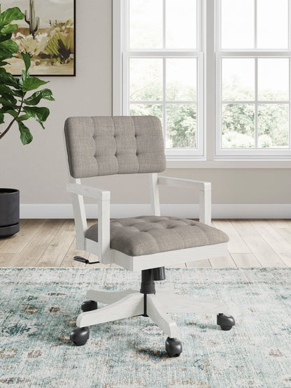 Upholstered swivel office chair with tufted light-gray back and seat, white base, casters.