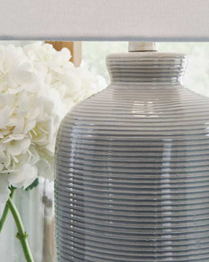 Ceramic lamp base close-up with horizontal ribbing and white drum shade