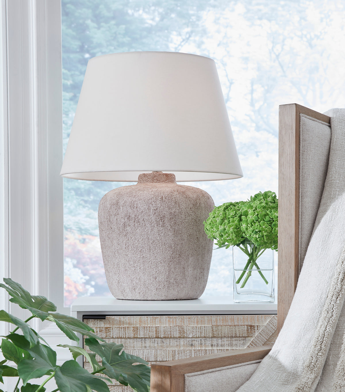 Ashley Danry metal table lamp with white fabric shade and textured beige base