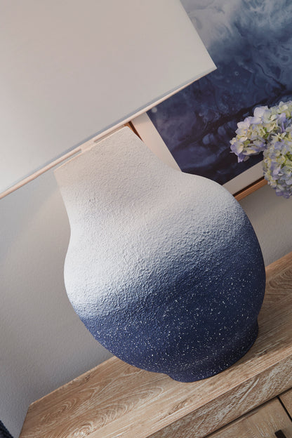 Blue speckled metal lamp base under white drum shade, angled view