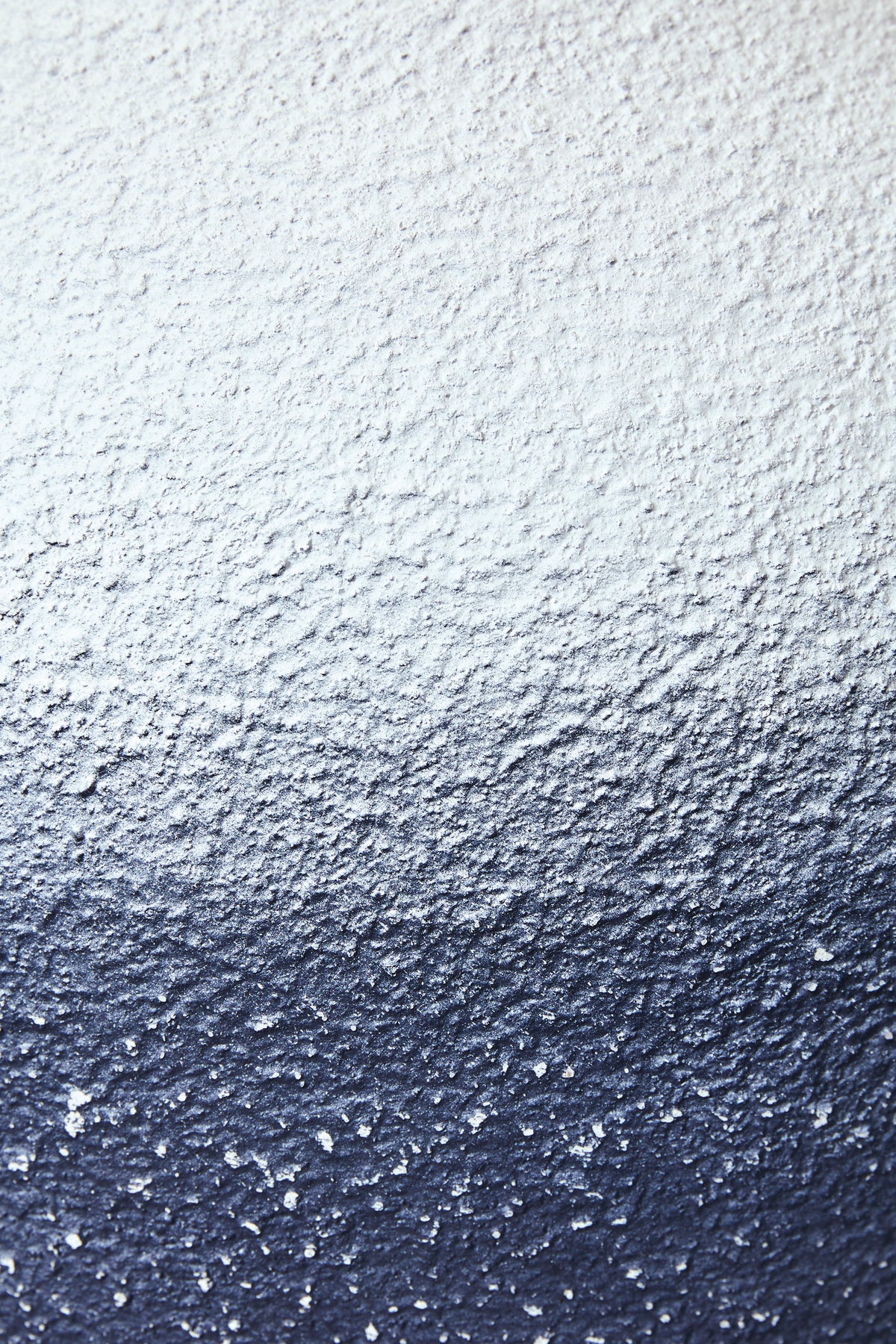Textured blue and white metal lamp base surface, speckled finish close-up