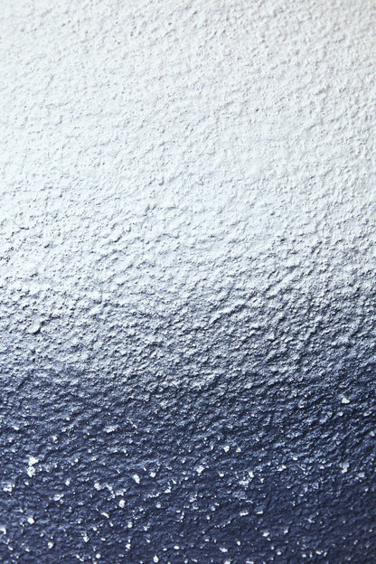 Textured blue and white metal lamp base surface, speckled finish close-up