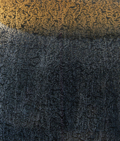 Close-up of lamp base finish: dark textured metal with gold rim