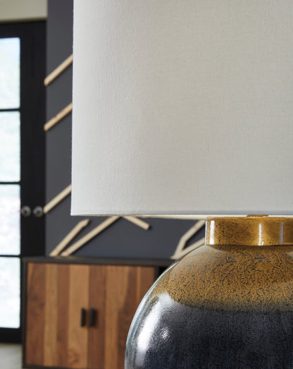 Lamp with white shade over dark textured metal base and gold collar