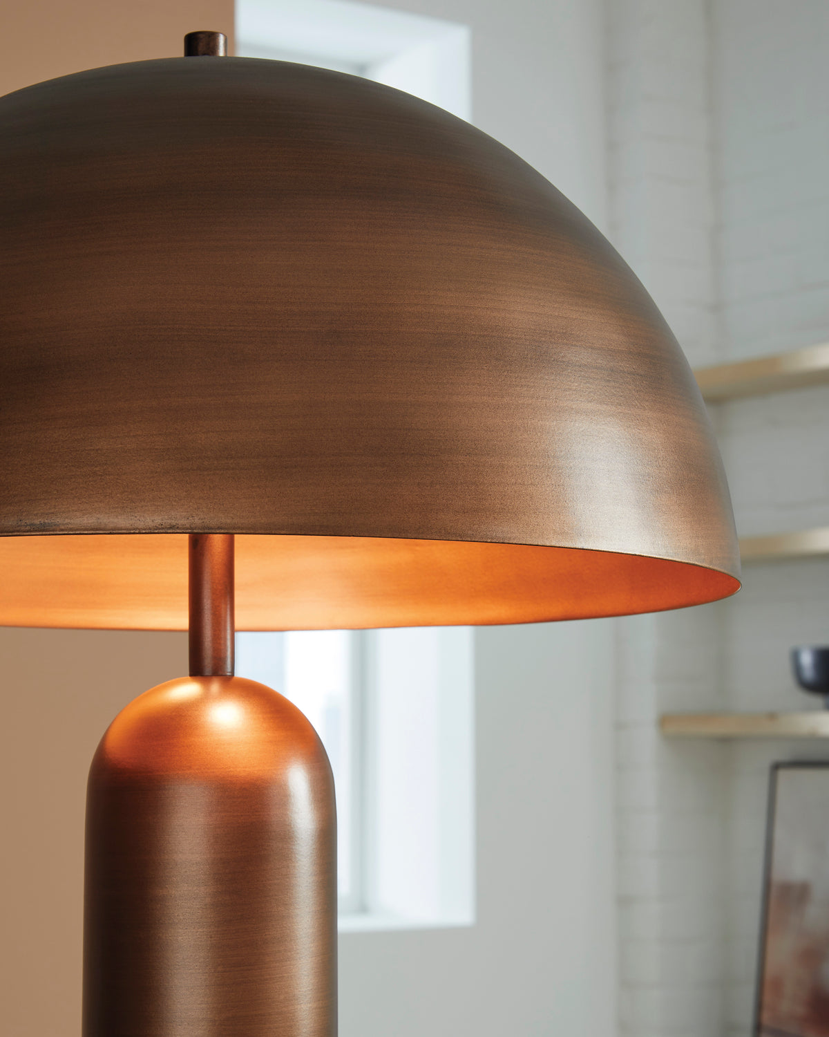 Copper dome lamp shade with warm inner glow and slim stem
