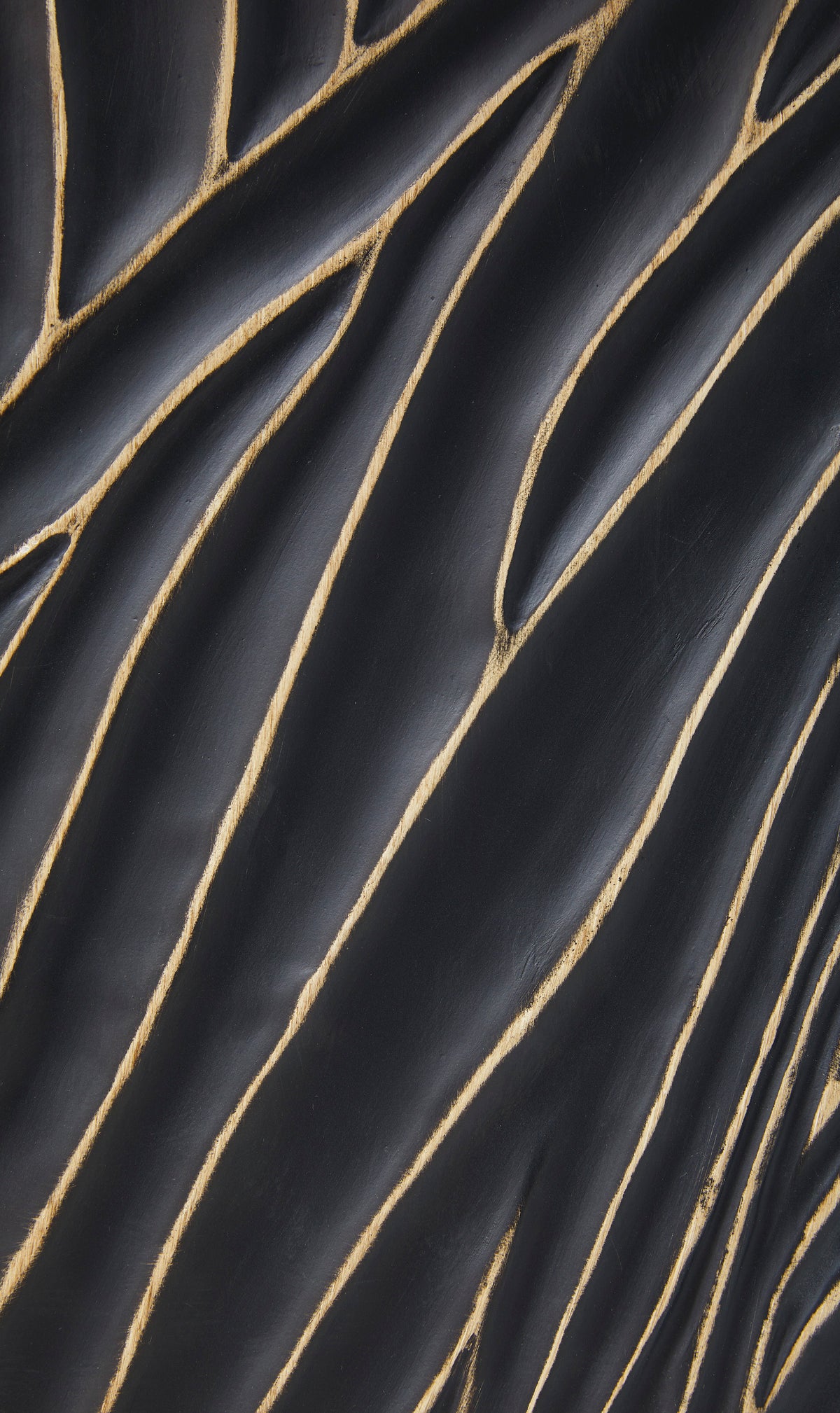 Close-up of black lamp base with gold curved line texture