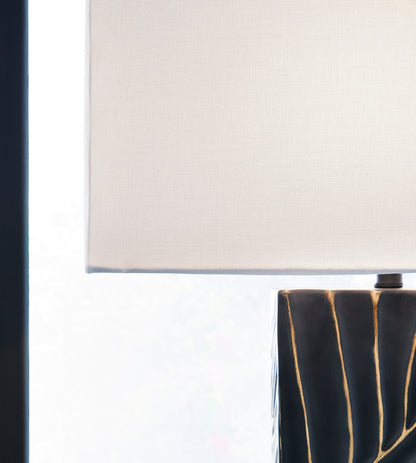 White fabric lamp shade over black base with gold vertical lines