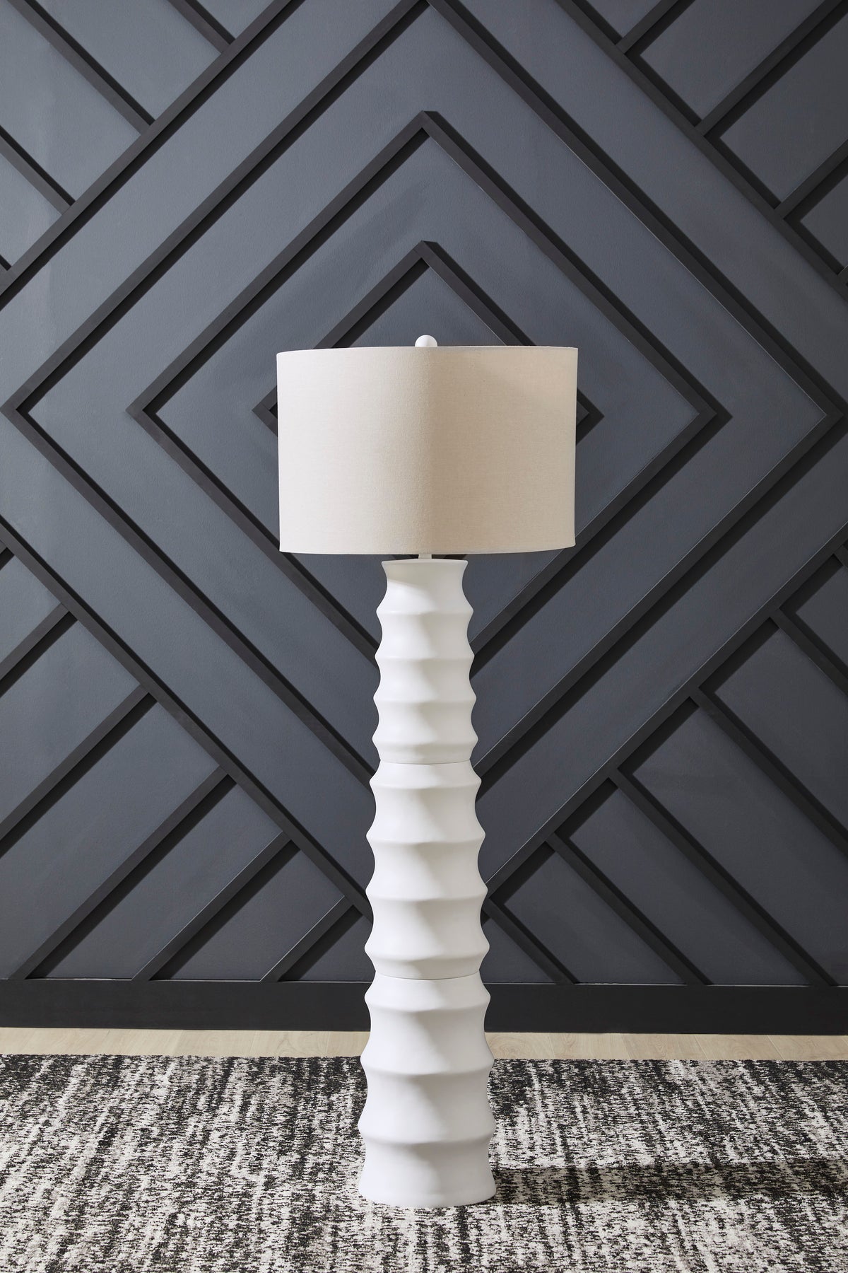 White floor lamp with ribbed column base and tapered fabric drum shade
