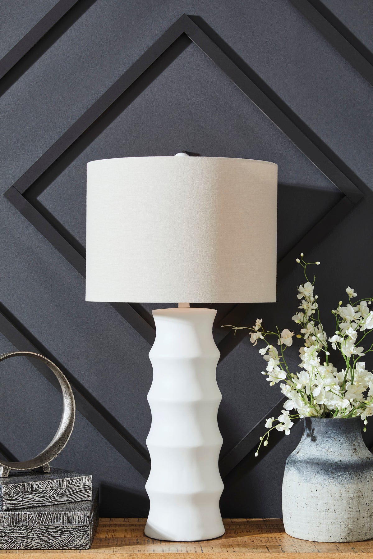 White ribbed ceramic table lamp with beige fabric drum shade