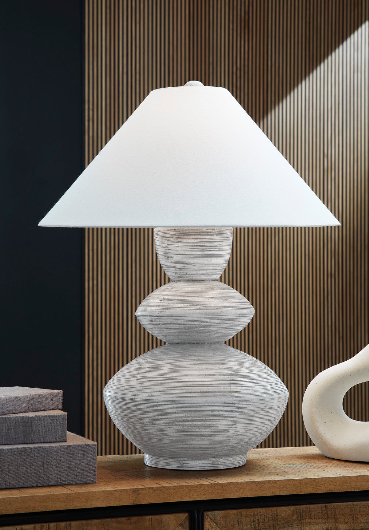 Table lamp with white fabric shade and gray stacked stone-textured base