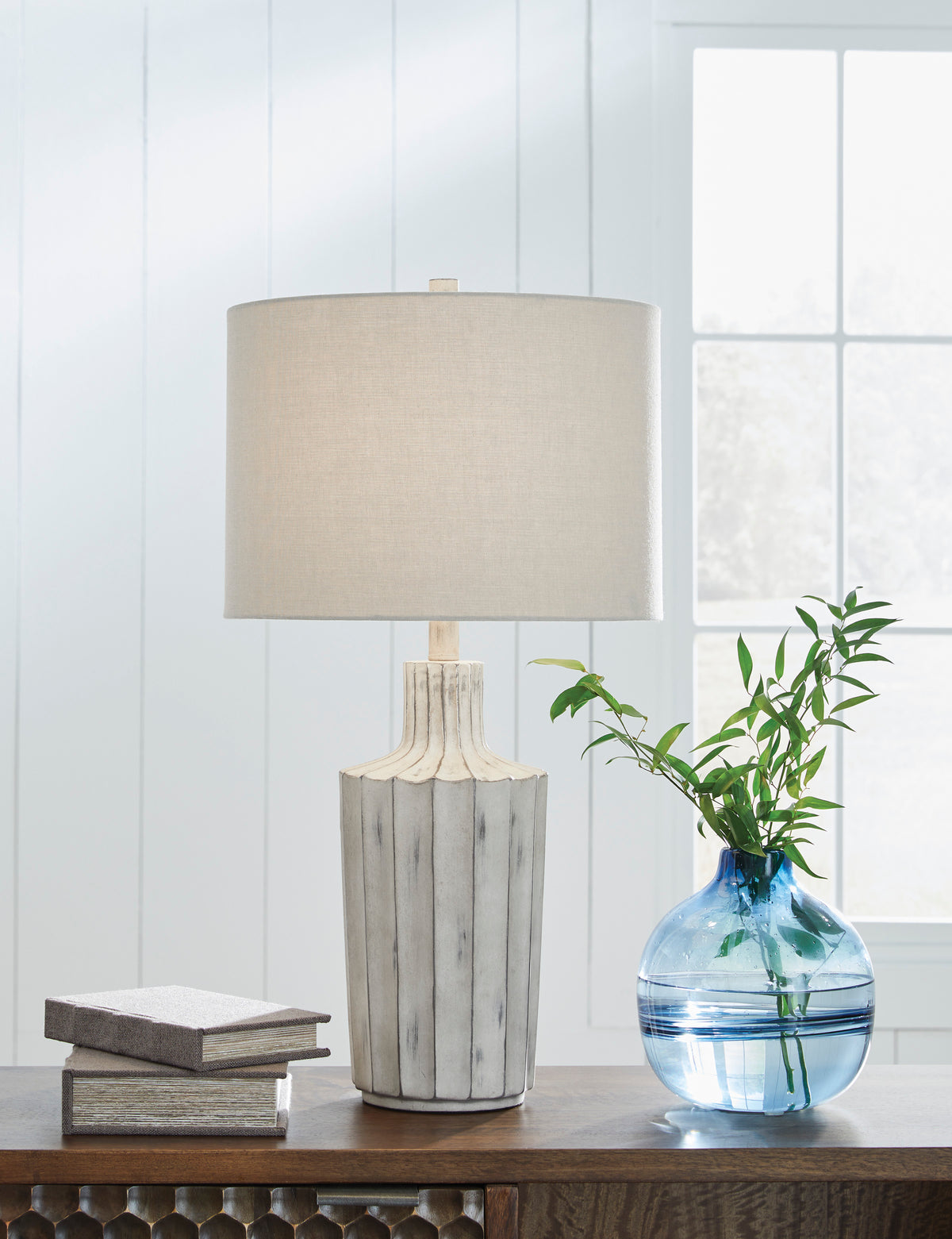 Table lamp with beige fabric drum shade and fluted gray ceramic base