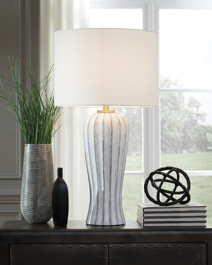 Table lamp with white drum shade and ribbed striped ceramic base with gold accents