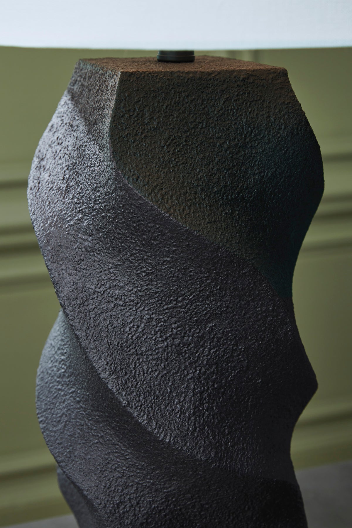 Textured black wavy base of a poly table lamp