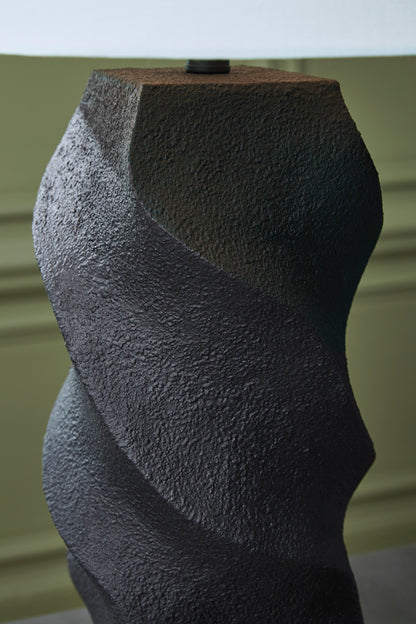 Textured black wavy base of a poly table lamp