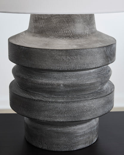 Table lamp base with dark gray stacked ring texture, close-up of top section